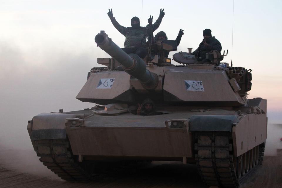  Iraqi forces flash the V-sign from a M1 Abrams tank as they approach the battlefront