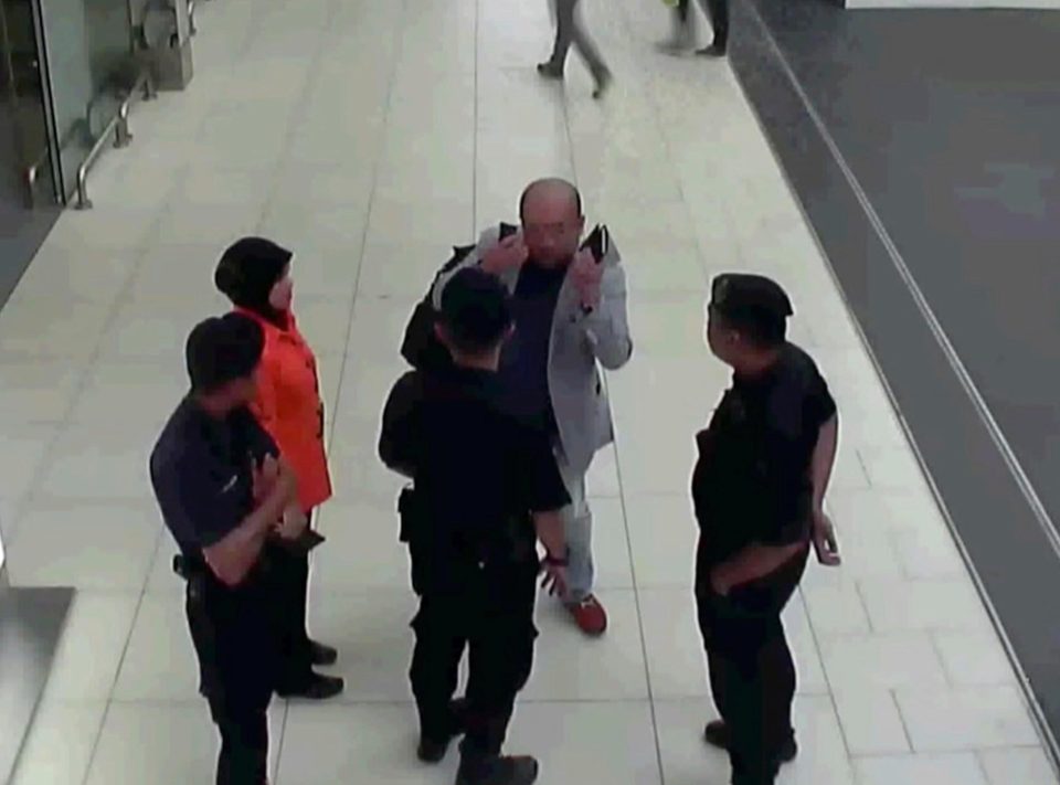  Kim shows airport officials how the women rubbed his face just minutes before he collapsed and died