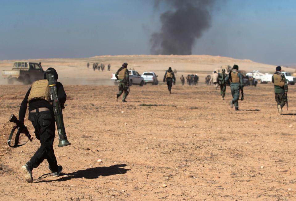  Smoke billows in the background as Iraqi forces, supported by the Hashed al-Shaabi (Popular Mobilisation) paramilitaries, advance