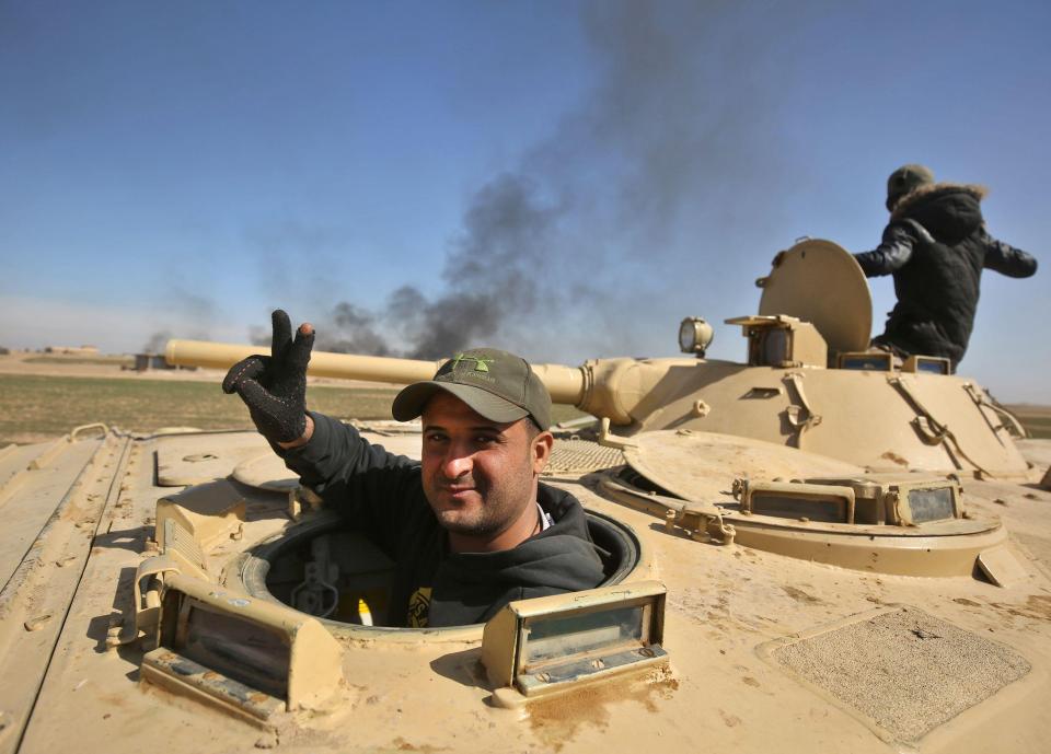  An Iraqi soldier gestures as forces, supported by the Hashed al-Shaabi (Popular Mobilisation) paramilitaries, advance near the village of Husseinyah