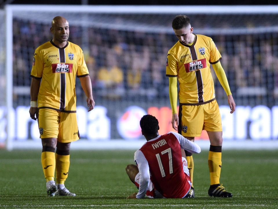 Iwobi lies on the GAnder Green pitch after being taken out