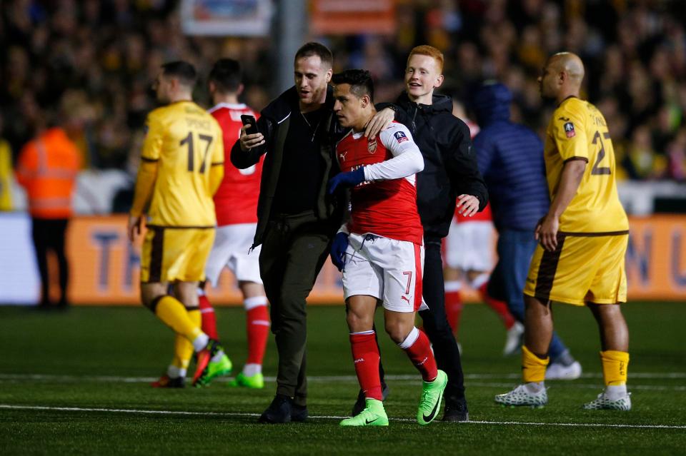 A fan tries to get a selfie with Alexis Sanchez at full-time