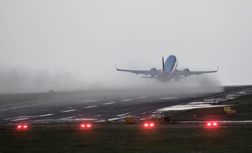  A plane takes off in wet weather this morning from Leeds Bradford Airport, but dozens of flights have been grounded as Storm Doris