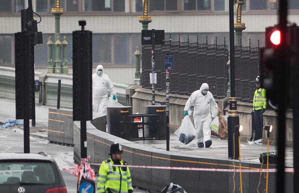  Forensic teams carry bags of evidence from Westminster Bridge where a maniac ploughed into crowds yesterday