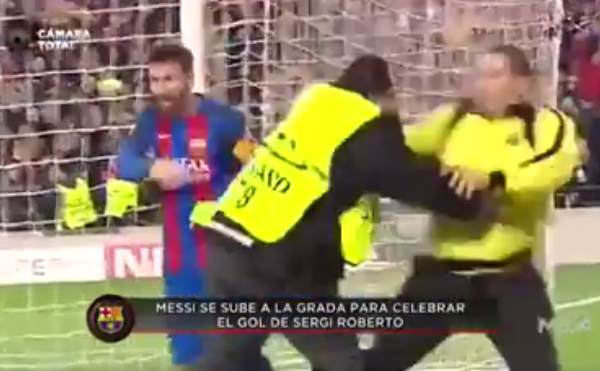  Lionel Messi dodges out the way as security tackle the pitch invader