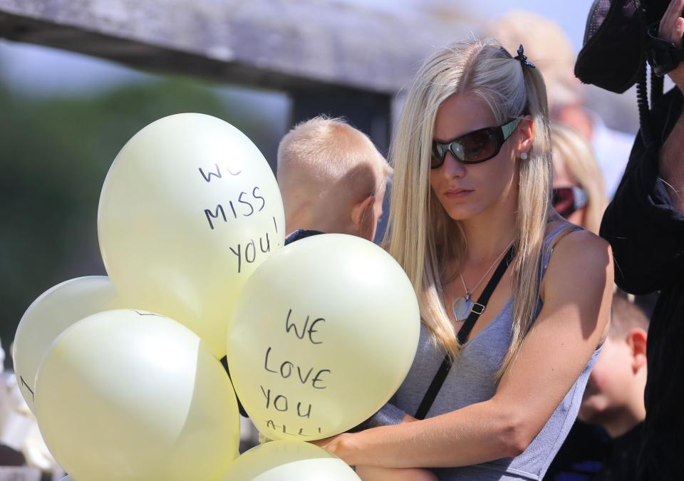  A woman holds balloons on the Toll Bridge in Shoreham, West Sussex, last year ahead of a memorial to mark the one year anniversary of the Shoreham air crash