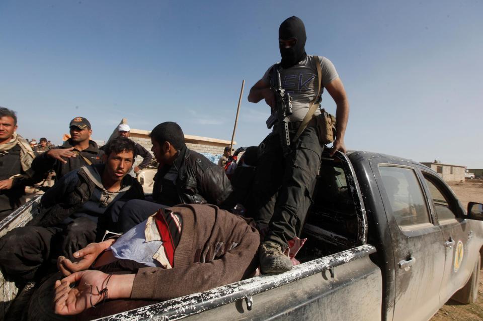  ISIS terror suspects sit cuffed in the back of a truck in western Mosul