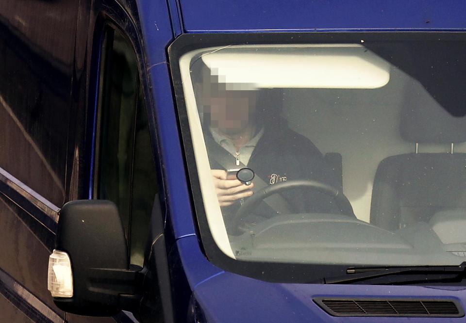  A van driver holding a mobile phone whilst driving on the M20 near Ashford, Kent