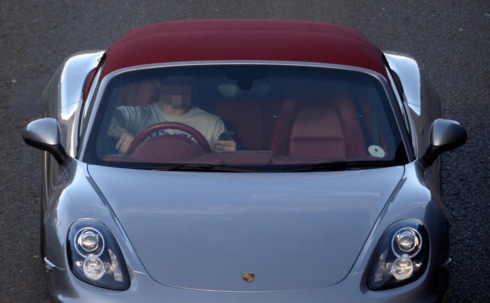  A driver holding his mobile phone while driving on the M8 through Glasgow