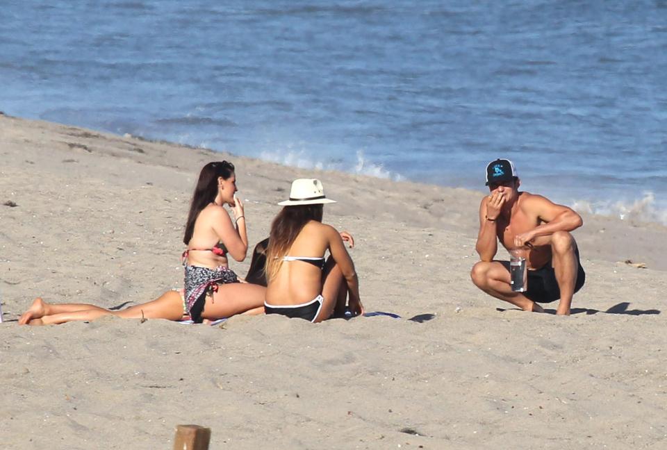  He perched in front of the women on the sand