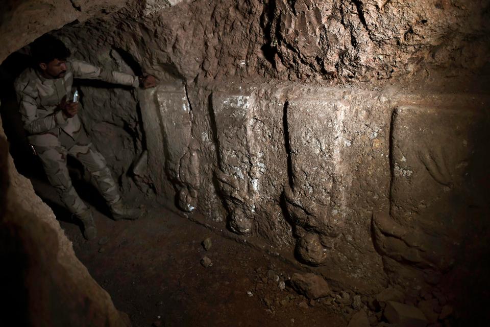  An Iraqi soldier stands beside some of the ancient stonework that was uncovered in eastern Mosul