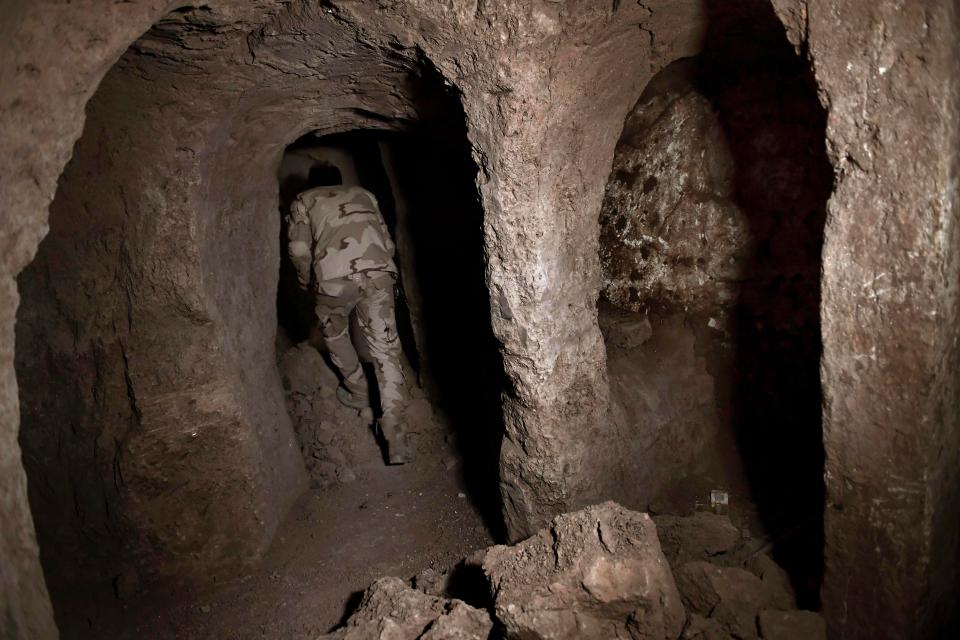  An Iraqi soldier leads reporters into the ancient underground palace in Mosul, Iraq