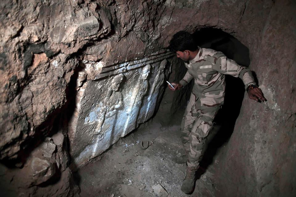  An Iraqi soldier shines his torch on some of the ancient carvings found in the tunnels beneath the Nabi Yunus shrine