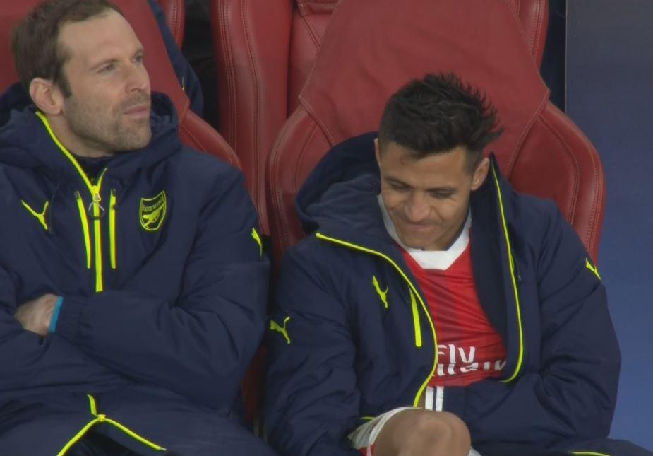  Alexis Sanchez tries to stifle a grin on the Gunners bench