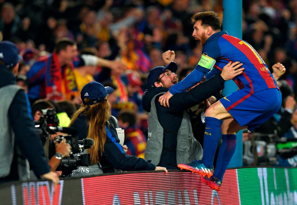  Lionel Messi jumps onto the advertising board to celebrate with Barcelona fans