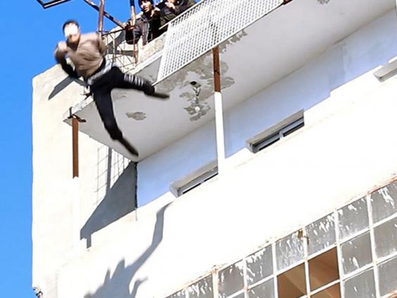  A man accused of being gay by the sickening terror thugs is thrown from the tower block in this file picture