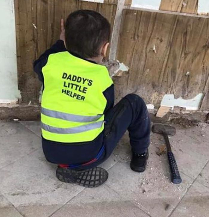  The brave little boy wore an adorable vest naming him 'Daddy's Little Helper'