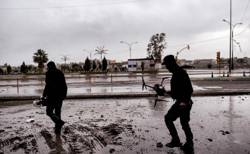  Members of the Iraqi forces prepare to fly a drone armed with grenades