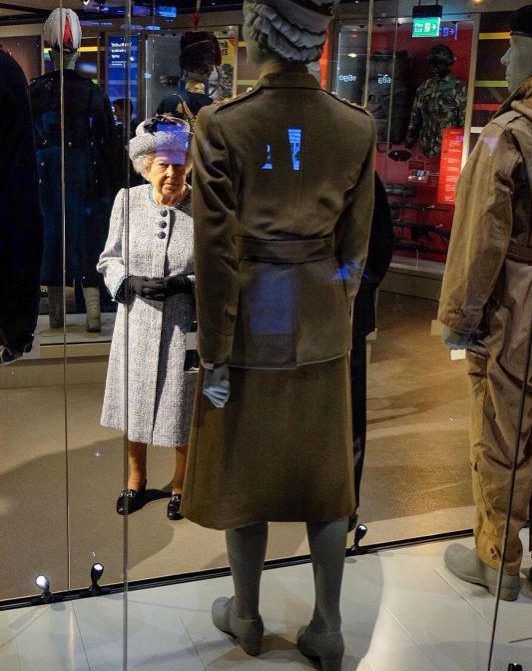  The Queen pauses as she inspects the army uniform she previously wore