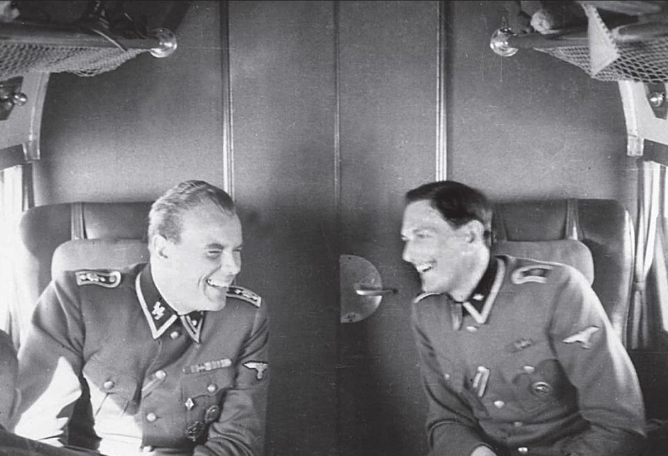  A revealing photo collection shows Nazi top brass joking, smiling as they relax on the way to Hitler's Alpine lair. Rochus Misch is pictured here, right, alongside Joseph Graf