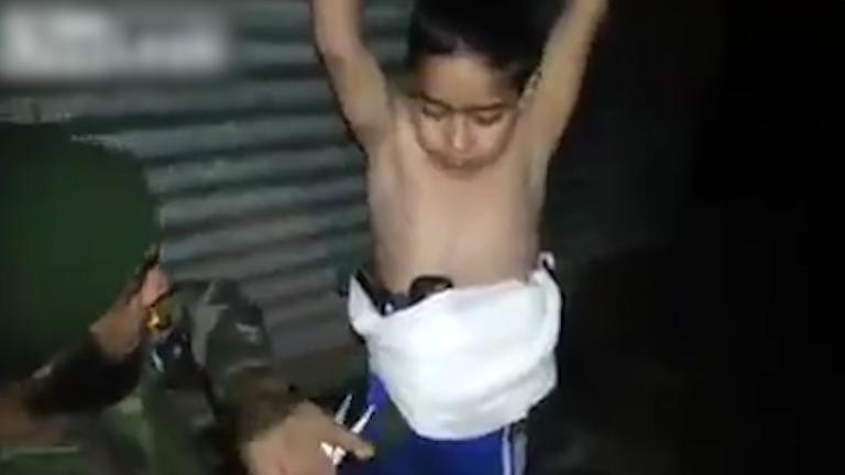  The young boy holds his arms up in the air while the Iraqi specialist is said to be deactivating the bomb