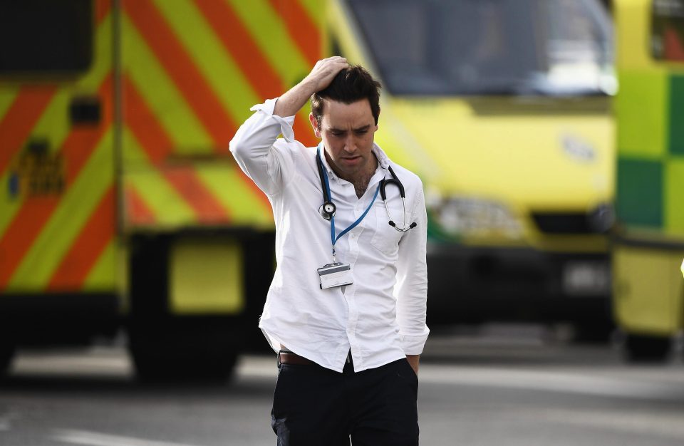  A doctor walks from the scene with his hand on his head after the attack