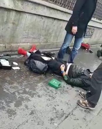  A man lies strewn across the pavement with a first aid kit next to him