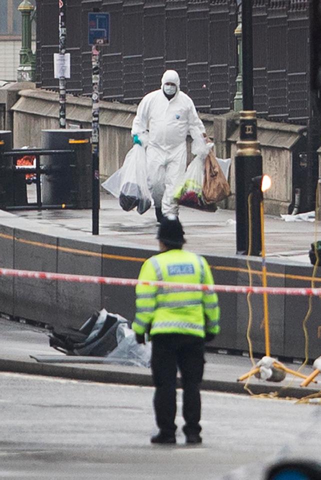  Forensic teams carry bags of evidence from Westminster Bridge where a maniac ploughed into crowds yesterday