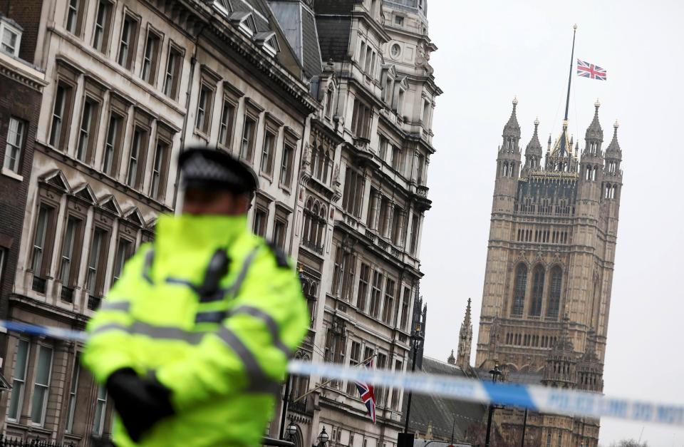  A police officer stands on duty as the union flag flies over Parliament at half-mast the morning after an attack by a man driving a car and wielding a knife left five people dead and dozens injured