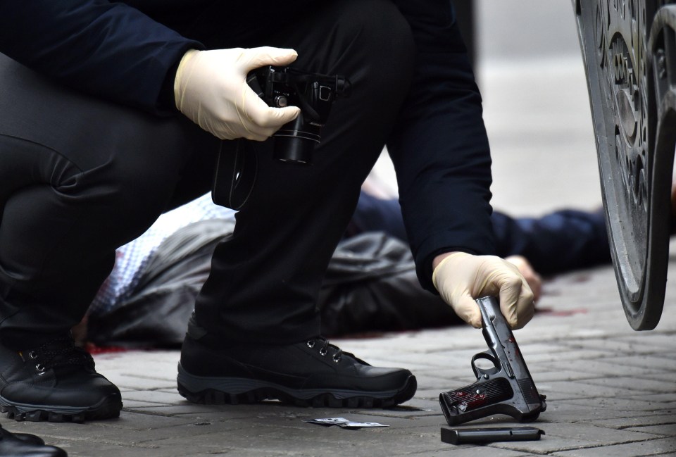 A Ukranian police officer lifts a gun potentially used in the murder of the ex-Russian MP