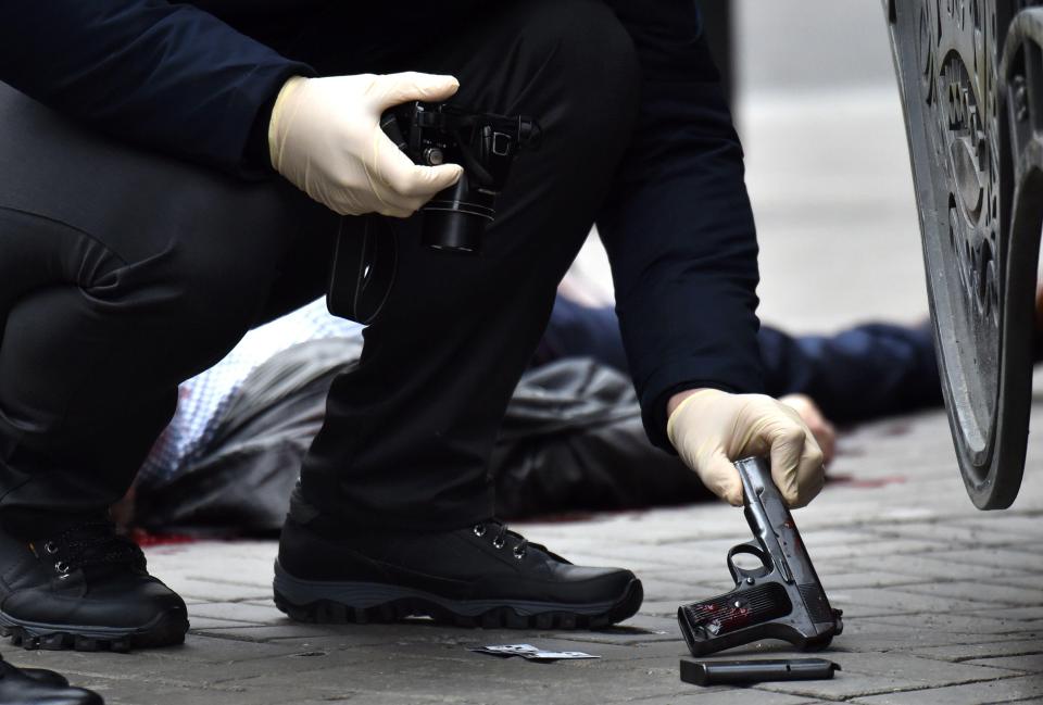  A Ukranian police officer lifts a gun potentially used in the murder of the ex-Russian MP