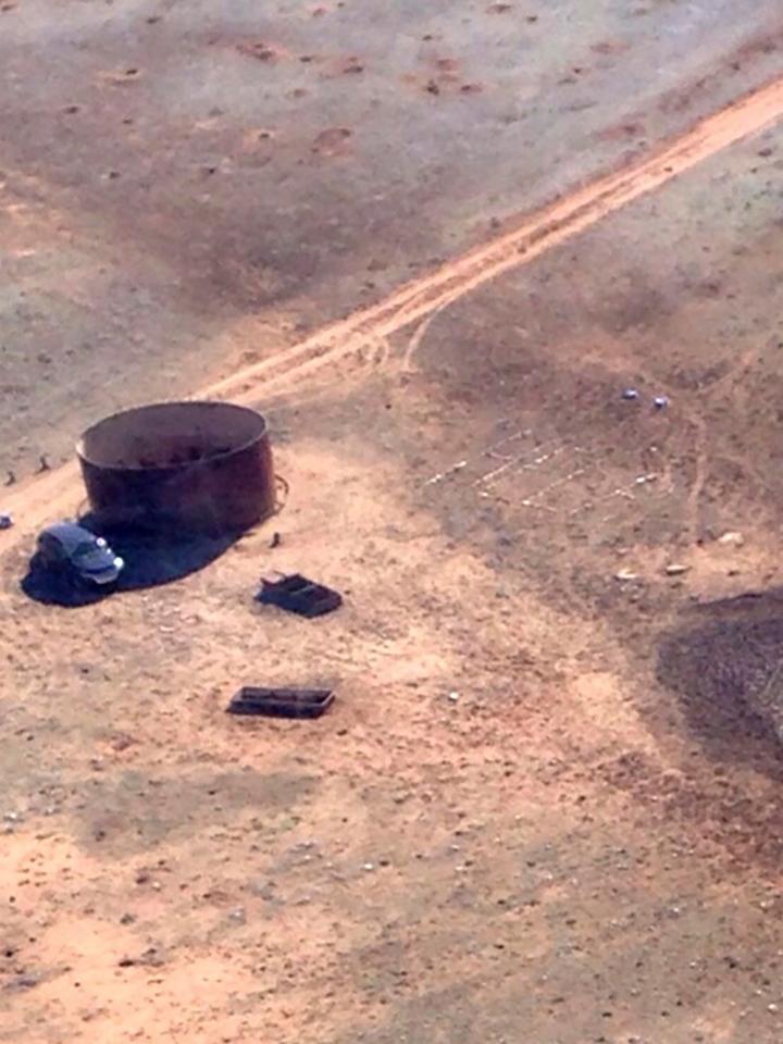  An aerial shot shows Amber's car in the sparse shade, with a desperate "help" message laid out in stones