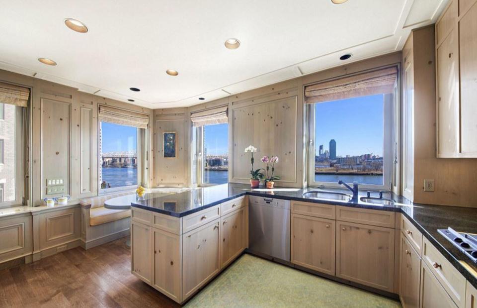 The stunning kitchen is decked out in wood panelling and boasts stunning views of the river