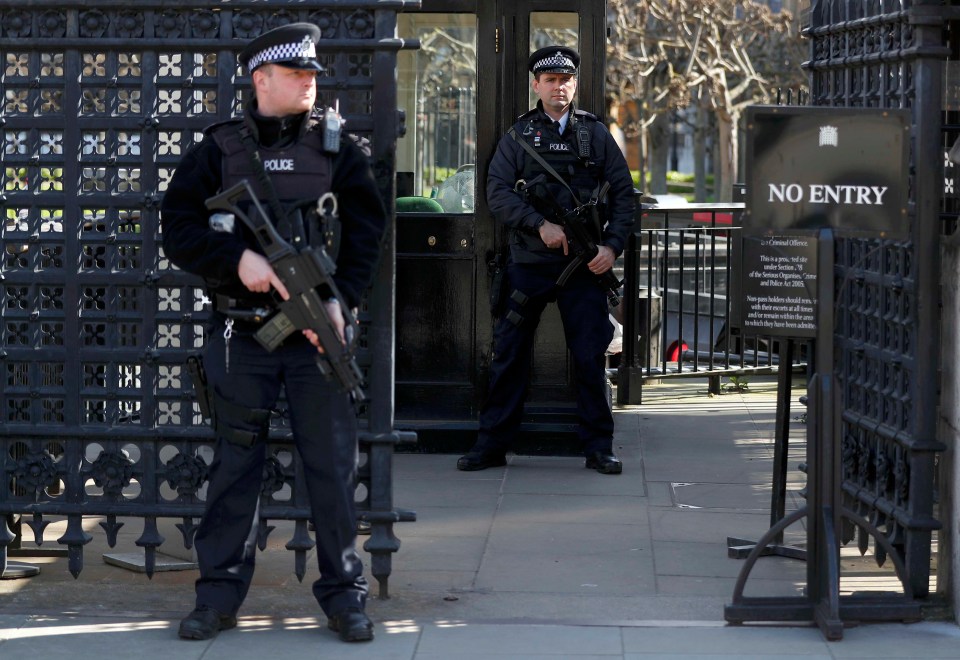 Armed police officers stand at the Carriage Gates entrance to the Houses of Parliament, following the attack in Westminster earlier in the week