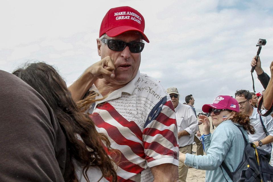 A man in a Make America Great Again hat gets punched by a protester 