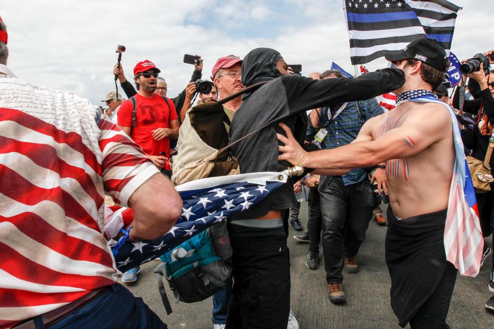 A protester lands a punch on a Trump supporter during the march 