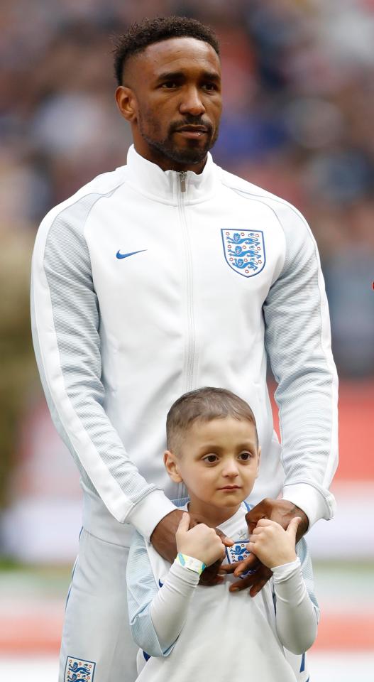  Bradley Lowery holds the hands of Jermain Defore before England play Lithuania