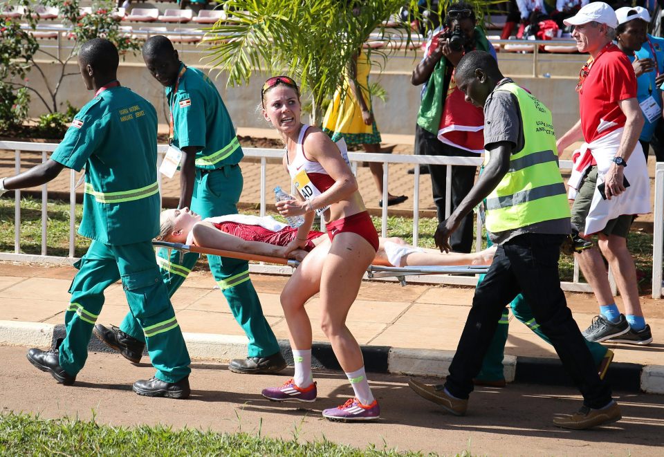  A worried runner accompanies a fellow competitor as she is taken away on a stretcher