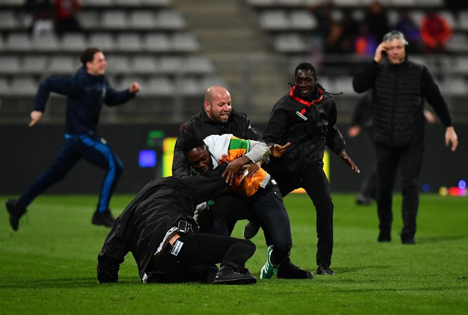  One supporter is swarmed by officials as chaos broke out in Paris