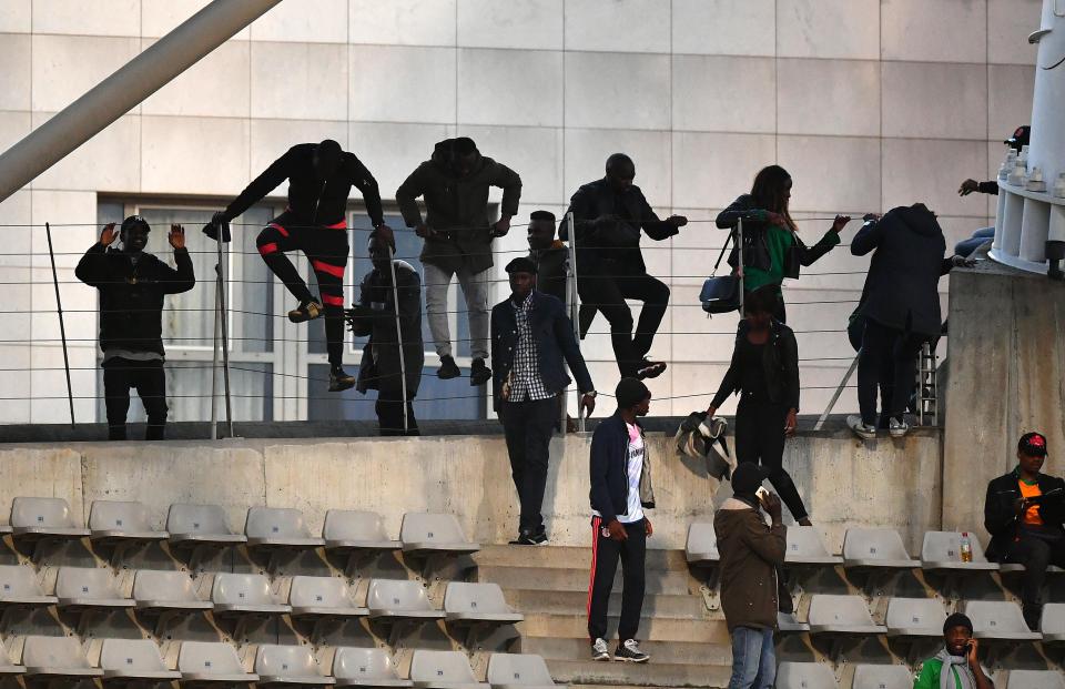  Fans can be seen sneaking into the stadium over a fence