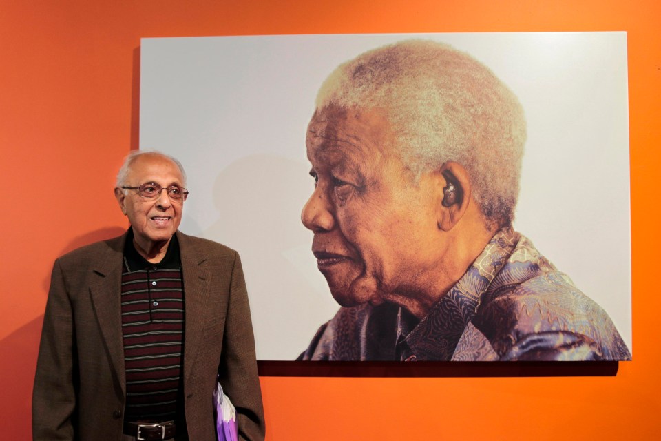 Ahmed Kathrada, a former South African political prisoner who spent 18 years in prison with late South African president Nelson Mandela, poses in front of his commrade's portrait at the Nelson Mandela Foundation in Johannesburg