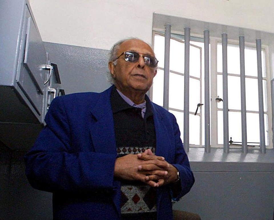 Ahmed Kathrada near the barred window in the jail cell of former fellow inmate Nelson Mandela a visit of the Robben Island prison, near Cape Town