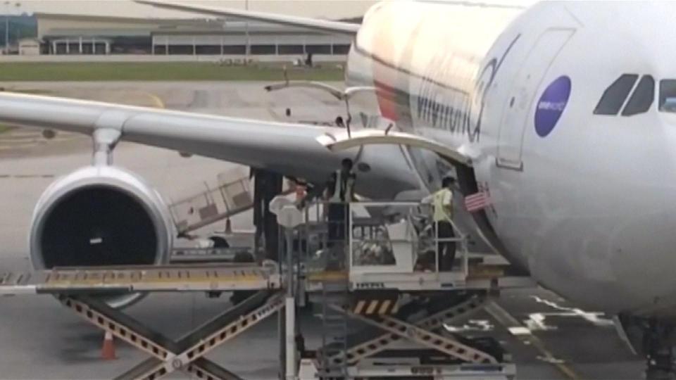  Officials load luggage onto the plane, including the coffin containing the body of Kim Jong-nam