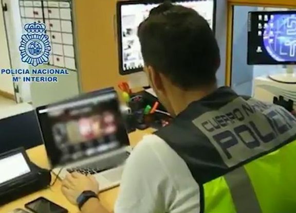 A police officer examines the website which is alleged to have put a girl's virginity up 