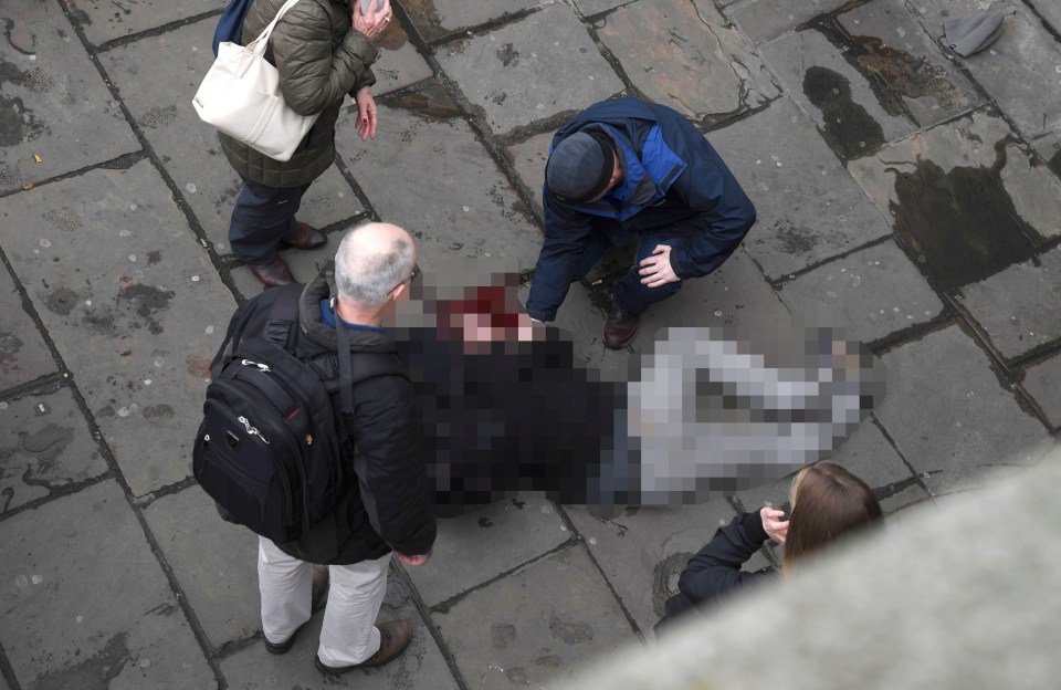 An injured man is assisted after the incident on Westminster Bridge