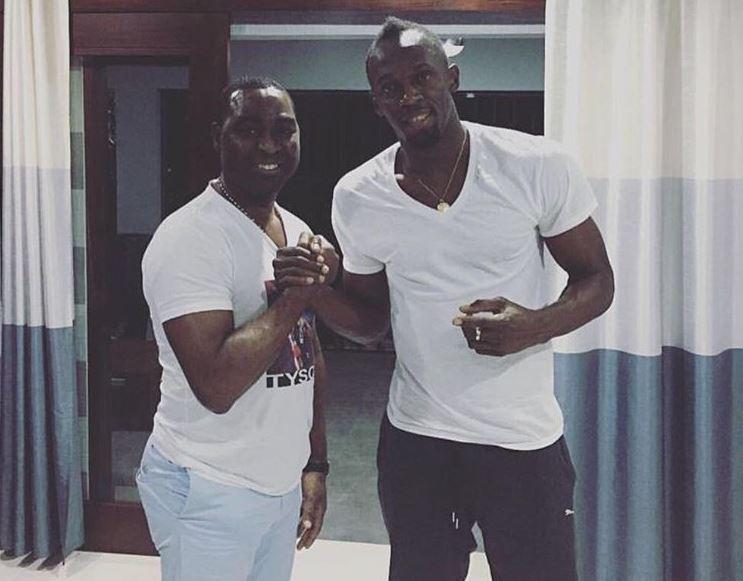  Ex-England striker Cole with champions sprinter Usain Bolt