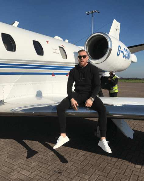  Conor proudly sat on the wing of the private jet as he arrived for the National