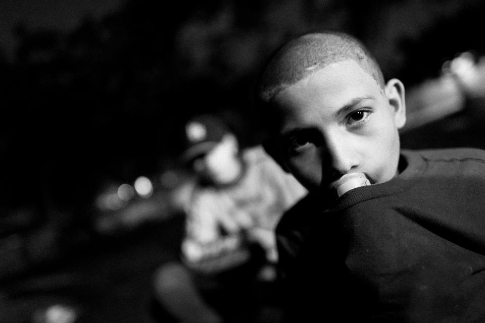  A young boy sniffs glue to get high while living on the street in San Salvador