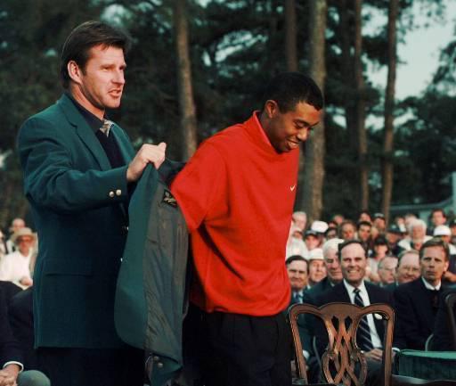  Previous winner Nick Faldo helps Woods with the jacket in 1997