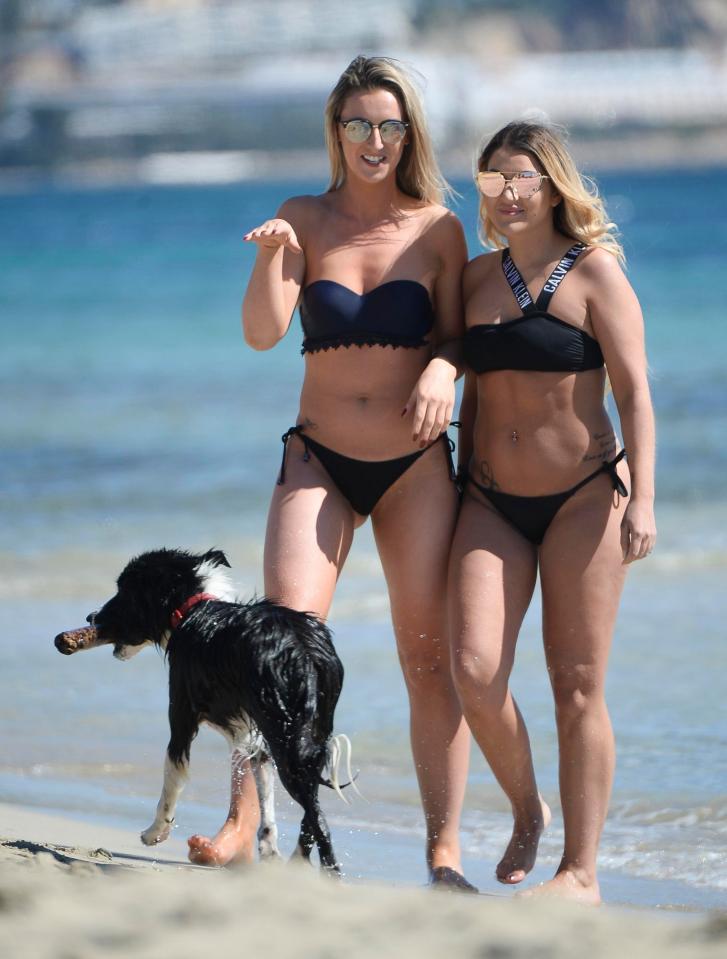  A dog dashes past the two friends as they enjoy a beach stroll